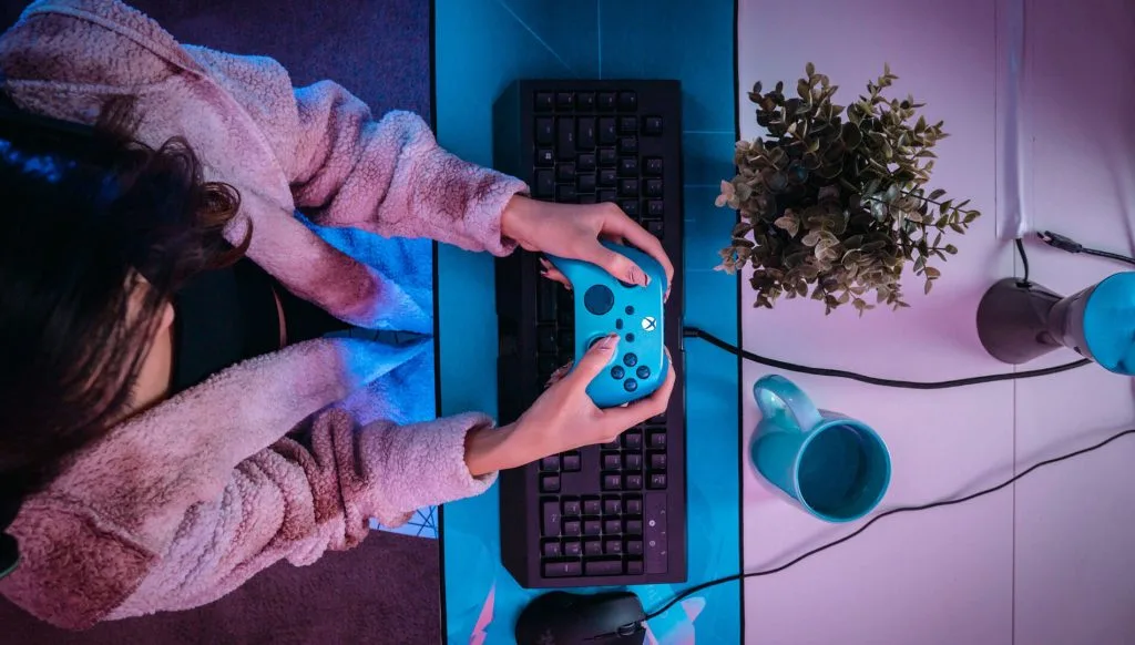 Дівчина тримає геймпад Xbox, тестуючи нові інтерактивні технології геймплею